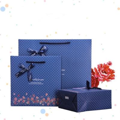 China Recyclable Customized Blue Flower With Bow Tie Paper Clothing Gift Bag With Handle for sale
