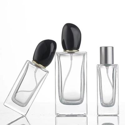 China Square Glass Perfume Bottle with 50ml 100ml Capacity and Distinctive Irregular-shaped Cap for sale