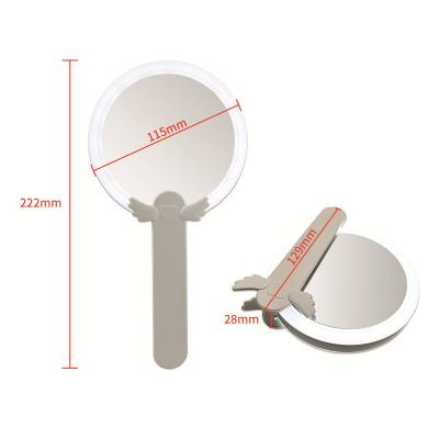China Handheld Double Sided Lighted Round LED Makeup Mirror 10X Beauty Mirror Vanity Table With Led Light Folding Makeup Mirror for sale
