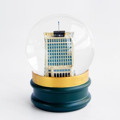 China Europe New Design Polyresin Bank Snowball Souvenirs Luxury Glass Building Resin Opens Empty Snow Globe Custom Snow Globes for sale