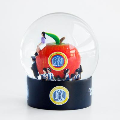 China Europe Students Graduation Gift Resin Crafts Apple Figure Students Throw Snowballs Custom Snow Globes Ornament Souvenir Snow Globe for sale