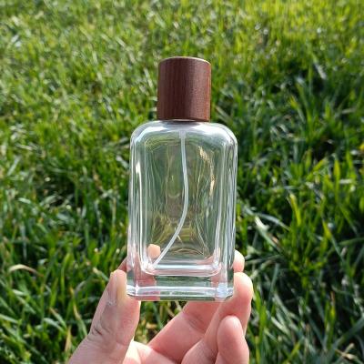 China Personal Care 50ml High Quality Glass Perfume Bottle Round Cosmetic Glass Bottle With Luxury Carbide Beech Cap for sale