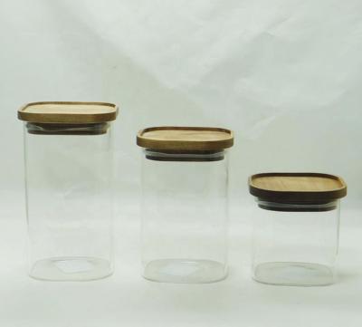 China Borosilicate heatable squarea glass storage jars with acacia wood lid for sale