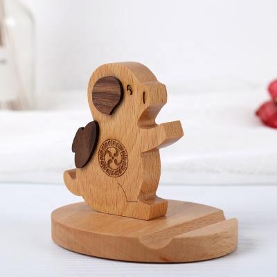 China Flexible Manufacturers Wholesale Multifunctional Solid Wood Pig Pen Hole Cell Phone Beech Mobile Phone Stand Elephant Base for sale