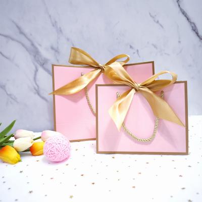 China Candy Gift Accessories Packing Light Pink Paper Bags With Ribbon Handles for sale