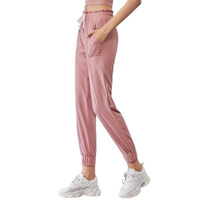 China Breathable Woman Waist Closing Loose Yoga Pants Running Toe Binding Pocket Leisure Training Quick Dry Loose Sweatpants for sale