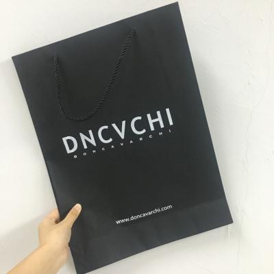 China Recyclable Wholesale Custom Printed Black Luxury Shopping Paper Gift Bag With Handle Suitable For Apparel Industry for sale