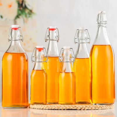 China Empty Round Beverage Liquor Beer Bottles With Loop Top Flip Top Easy Glass Wine Juice Beverage Bottle for sale