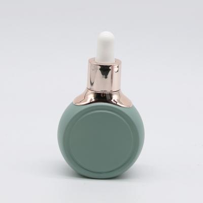 China 2oz 60ml Cosmetic Flat Round Shape Essential Oil Bottle Serum Glass Bottle With Dropper for sale