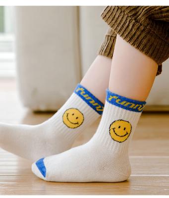 China Children's QUICK DRY smile solid color face student socks new baby autumn and winter trend color socks bright English medium tube socks for sale