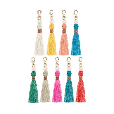 China Eco-Friendly Fashion Handmade Woven Wooden Bead Tassel Key Chain Rice Beads Bag Accessories for sale