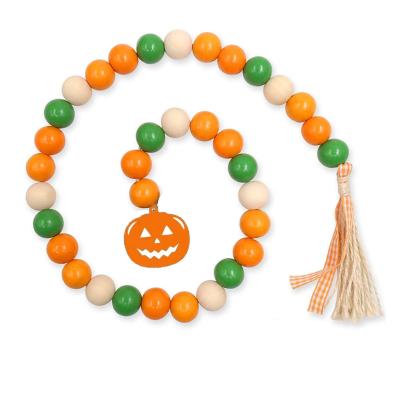 China Disposable Eco-friendly Latest Pumpkin Wooden Beads String Tassel Wall Hanging Decoration Halloween Wall Decor for sale