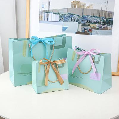 China Wholesale Recyclable Luxury JuYi Valentines Day Apparel Cardboard Gift Packaging Gift Shopping Garment Paper Bag With Bow Tie Ribbon for sale