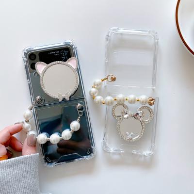 China Fashion Anti-fall Mirror Stand Clear Cover Device With Pearl Wrist Strap For Samsung Z Flip 3 Phone Case for sale