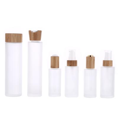 China Cosmetic Packaging Customized Clear Frosted Glass Toner Lotion Bottle With Bamboo Lid for sale