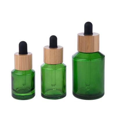 China 15ml 30ml 60ml cosmetic green glass cosmetic bottle with dropper and bamboo cap for sale