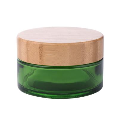 China 50g 100g Cosmetic Green Glass Cream Jar With Bamboo Lid China Custom Bamboo Cosmetic Jar Packaging for sale