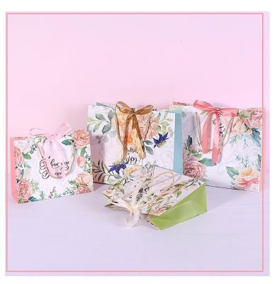 China Biodegradable Colorful Bowknot Ribbon Advertising New Products Kraft Cardboard Paper Bag For Free Sample for sale