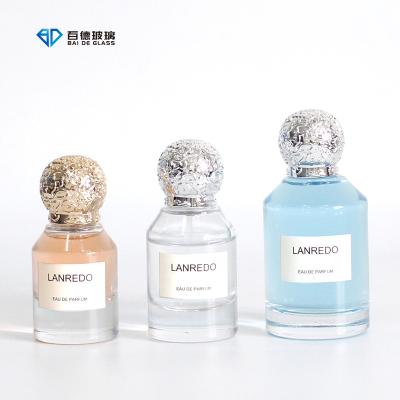 China Cosmetic wholesale luxury 30ml 50ml 100ml round spray cap empty glass bottle perfume bottle packaging with dome shape lid for sale