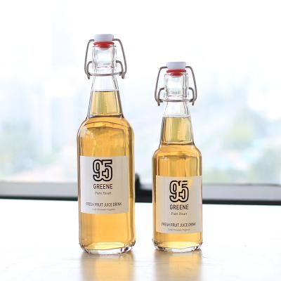 China Beverage Hot sales clear or amber 350ml 500ml round glass drink juice Kombucha bottle with swing cap for sale