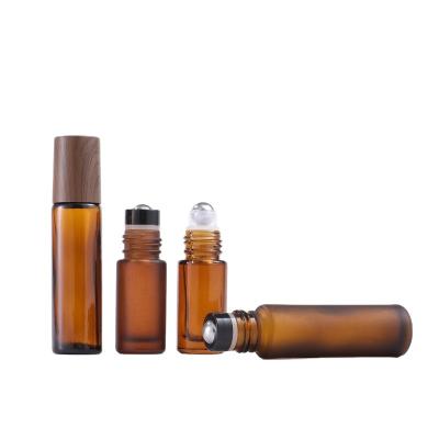 China New 5ml 10ml Amber Blue Clear Deodorant Attar Essential Oil Cosmetic Empty Roll On Glass Bottles With Wood Grain Caps for sale