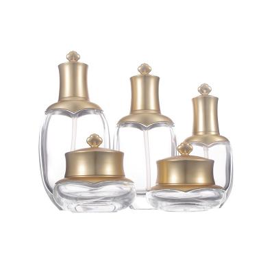 China Free Sample Cosmetic Luxury Gold Cosmetic Jar And Bottle Packaging Crown Cap Acrylic Lotion Bottle Cosmetic Set for sale