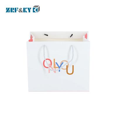 China Recyclable CMYK Printing White Kraft Paper Shopping Bag With Knotted Handle for sale