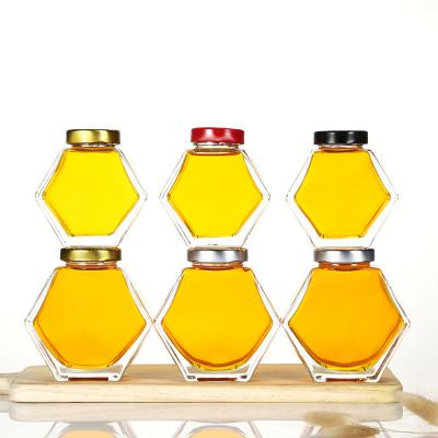 China 180ml 230ml 350ml Clear Honeycomb Hexagon Glass Viable/Stored Packaging Bottles For Pure Honey Jam Empty Glass Honey Jar With Tinplate Cover for sale