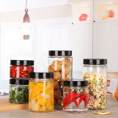 China Sustainable Right Side Round Clear Empty Glass Storage Bottle Block Herb Canned Pickle Jar Glass Honey Jar With Sealed Twist Off Lids for sale