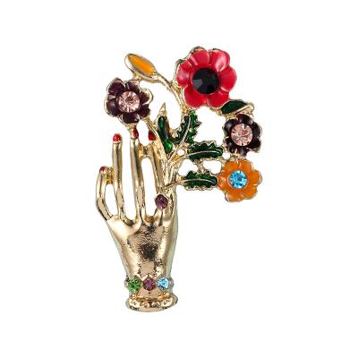 China Trendy Enamel Gold Plating Rhinestone Brooches Hand Flower Brooches Women Brooch Custom Made for sale