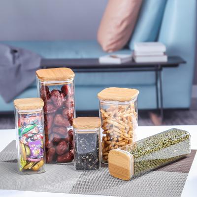 China Stocked Storage Round Glass Bottle With Bamboo And Wooden Kitchen Cereal Cover Transparent Sealed Jar for sale