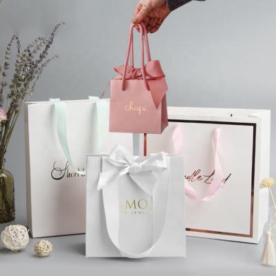 China Eco Friendly Gold Logo Stamping Rose Small Foiled Colorful Paper Cosmetics Bags With Ribbon Handle for sale