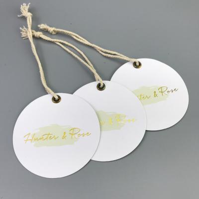 China Durable White Matte Coated Paper Clothing Tag Gold Foil , Garment Labels For Own Logo Clothing for sale