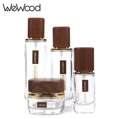 China Fashionalbe Custom Wooden Cap Container Empty Cosmetic Packaging Skin Care Glass Bottles Sets With Label for sale