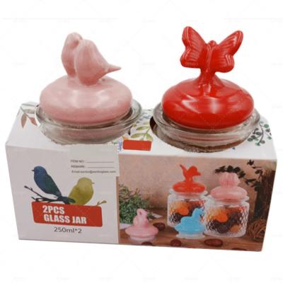 China Wholesale Freshness Keeping Ribbed Sweet Glass Candy Storage Jar With Ceramic Bird Butterfly Lid for sale