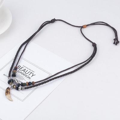 China Graceful Ethnic Woven Jewelry Beads Braided Retro Crescent Moon Pendant Hollow Brown Men Tie Leather Necklace for sale