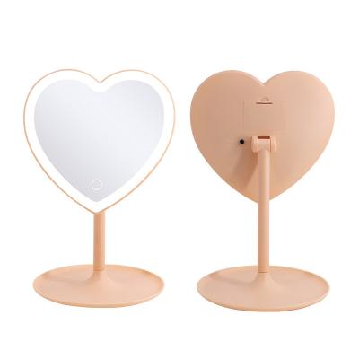 China Mini Heart LED Lighted Heart Shape Handheld Touch Screen Cosmetic Lighted Makeup Mirror With Storage Tray for sale