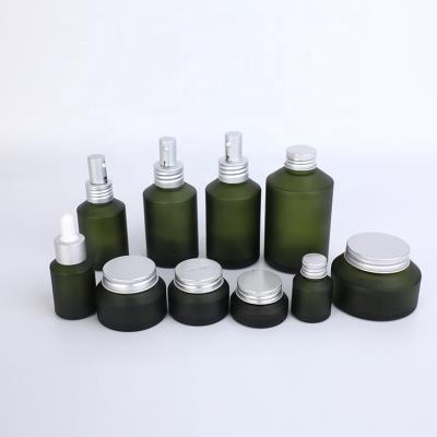 China Unique Design Perfect Printing Tilted Shoulder Recyclable Olive Glass Cosmetic Bottles And Jars For Skin Care Packaging Custom Size Wholesale for sale