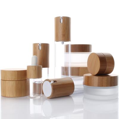 China Personal Care Glass Bottles Glass Cosmetic Jar With Bamboo Lid For Oil Pump Lotion Cap for sale