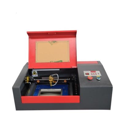 China Interesting 40w 50w 3020 Water Cooled Best Quality Cheap Price 40w 50w 3020 Nameplate CO2 Laser Cutter and Strip Engraving Machine for sale