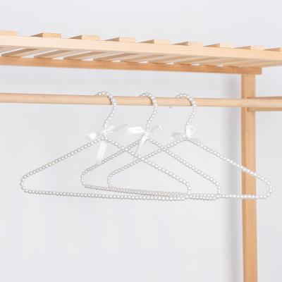 China Elegant and Beautiful High Quality Round and Shiny Bright Pearl White Hanger ABS Pearl White with Wire Bow Design Hanger for sale