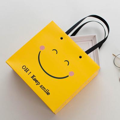 China Recyclable Handbag Face Business Gift Paper Bag Clothing Kraft Paper Bag Simplicity Smile Festival for sale