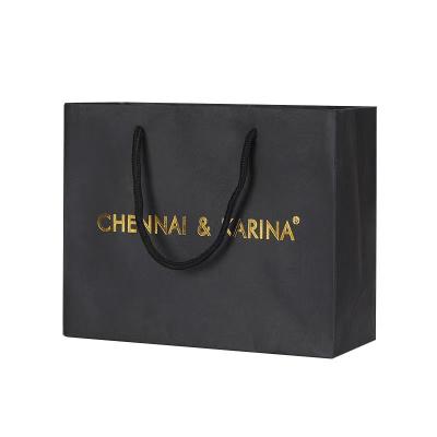 China Custom Hot Recycled Materials Gold Logo New Foiled Stamped Black Matte Paper Bag With Rope Handles For Package for sale