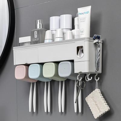 China Sustainable Automatic Squeezing Toothpaste Dispenser With Plastic Toothbrush Holder for sale