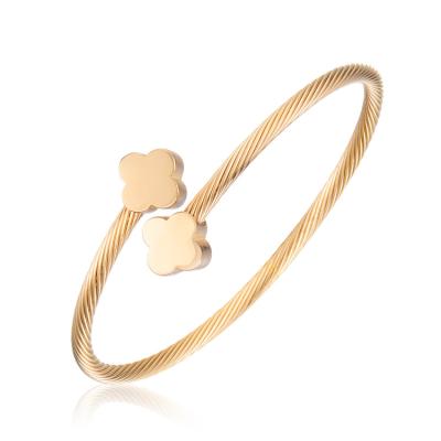 China Trendy simple cuff bracelet with four leaf pendant in 18k gold plated color. stainless steel open bangle for sale