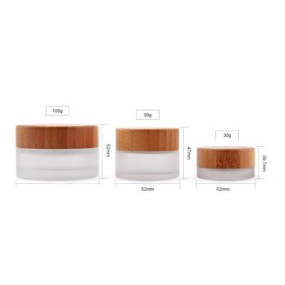 China OEM 50g 100g Cosmetic Clear Glass Cosmetic Jars Container With Bamboo Lids for sale