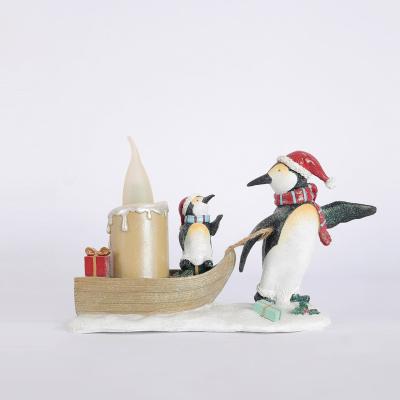 China Traditional polyresin crafts penguin uses boat pulling her baby and candle for home modern sculpture interior decoration for sale