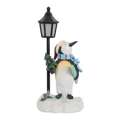 China Contemporary Abstract Polyresin Home Decoration Resin Christmas Street Light Penguin Sculpture With LED Flickering Flame for sale