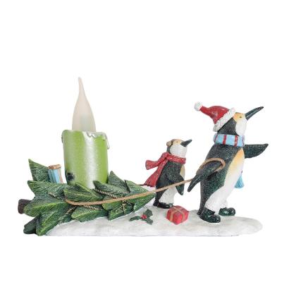 China Traditional Resin Figurines Animal Penguin And Her Baby Pulling Tree And Big LED Candle Penguins Figurines for sale