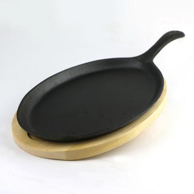 China Non Stick Sustainable Sizzling Fajita Pan Oval Cast Iron Fry Pan With Wooden Base for sale